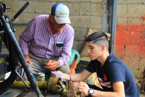 Luis Cordero Mangual, founder of the Cordero Dairy in Puerto Rico, assists Angel Torres, a Crop Science major from Oregon State University, in 2016. (contributed photo)