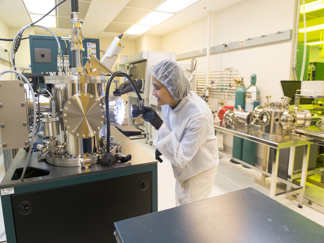photo of lab with scientist looking into lab equipment as part of semiconductor development