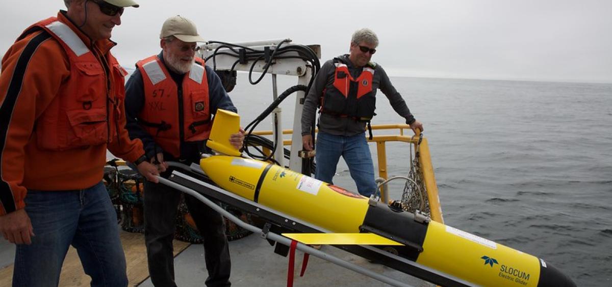 Researchers deploy a glider off a research boat to collect data from the ocean.