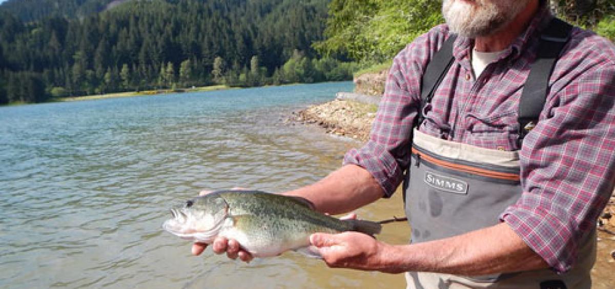 Randy Wildman holds a largemouth bass he caught in Fall Creek Reservoir