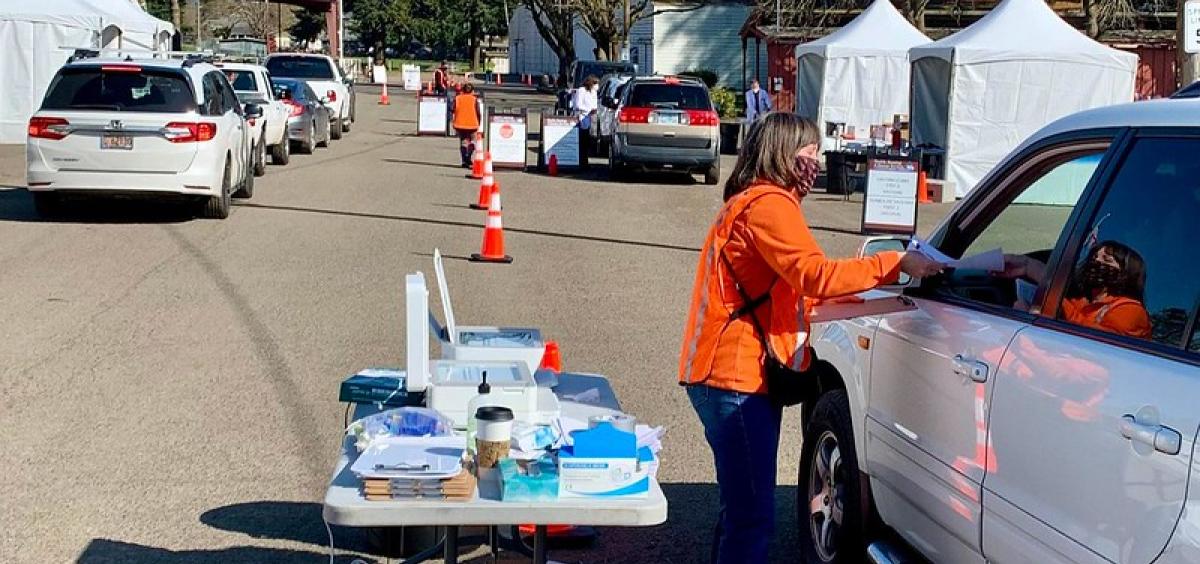 Jan Williams, with the OSU Extension Service in Clackamas County, collects paperwork from participants before they receive their shot at the drive-through COVID-19 vaccination clinic on March 31 in Canby. 