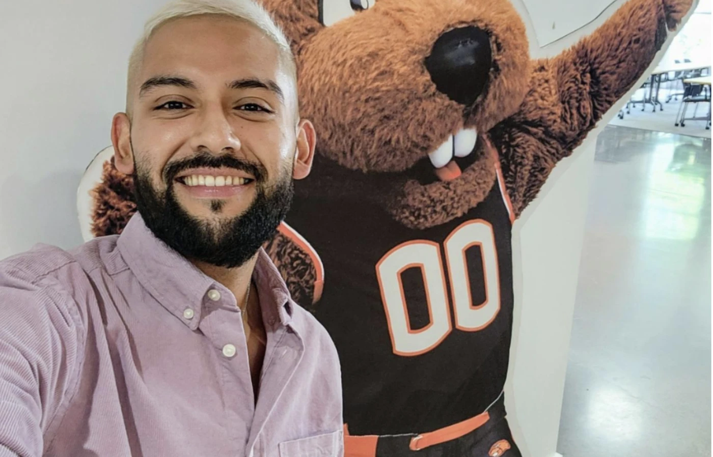 Freddy Leon takes a selfie with a cardboard cutout of Benny the Beaver