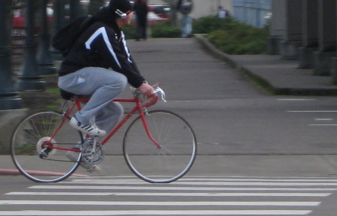 A student rides a red bike around campus.
