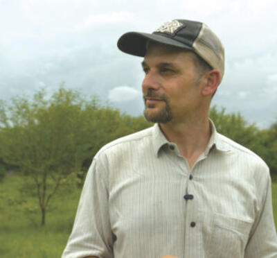 Andrew Millison wearing a baseball cap outdoors