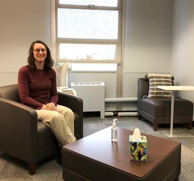 Clinic director Bridget Klest sitting in an armchair in front of a window.