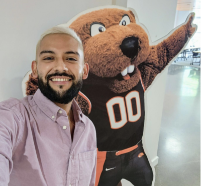 Freddy Leon takes a selfie with a cardboard cutout of Benny the Beaver