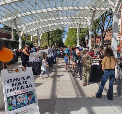Orange and black balloons mark the entrance to the sunny and crowded SEC Plaza during Bring Your Kids to Campus Day.