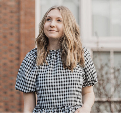 Lily Oliphant poses outside a red-brick building.