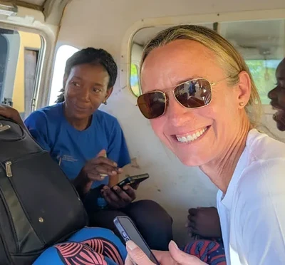 Liz Blanton smiling in a van with three other researchers in Zambia.