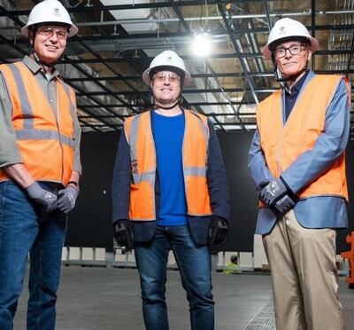 Men in hard hats and orange vests at construction site