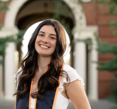 Lauren Pethick posing in her graduation stole on campus.