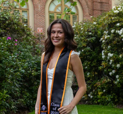 Siena Wong posing in her graduation stole on campus.