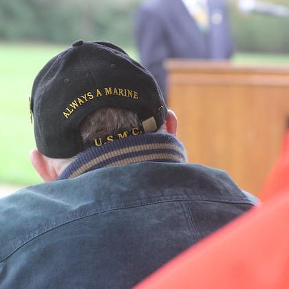 An image from a Veterans Day ceremony at OSU shows an older man wearing a baseball cap that says "Always a Marine."