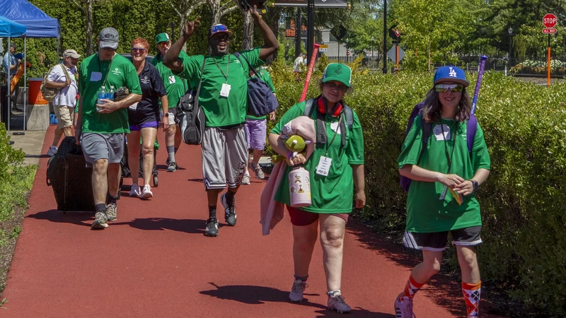 A group of people wearing bright green t-shirts walk along a path at OSU.