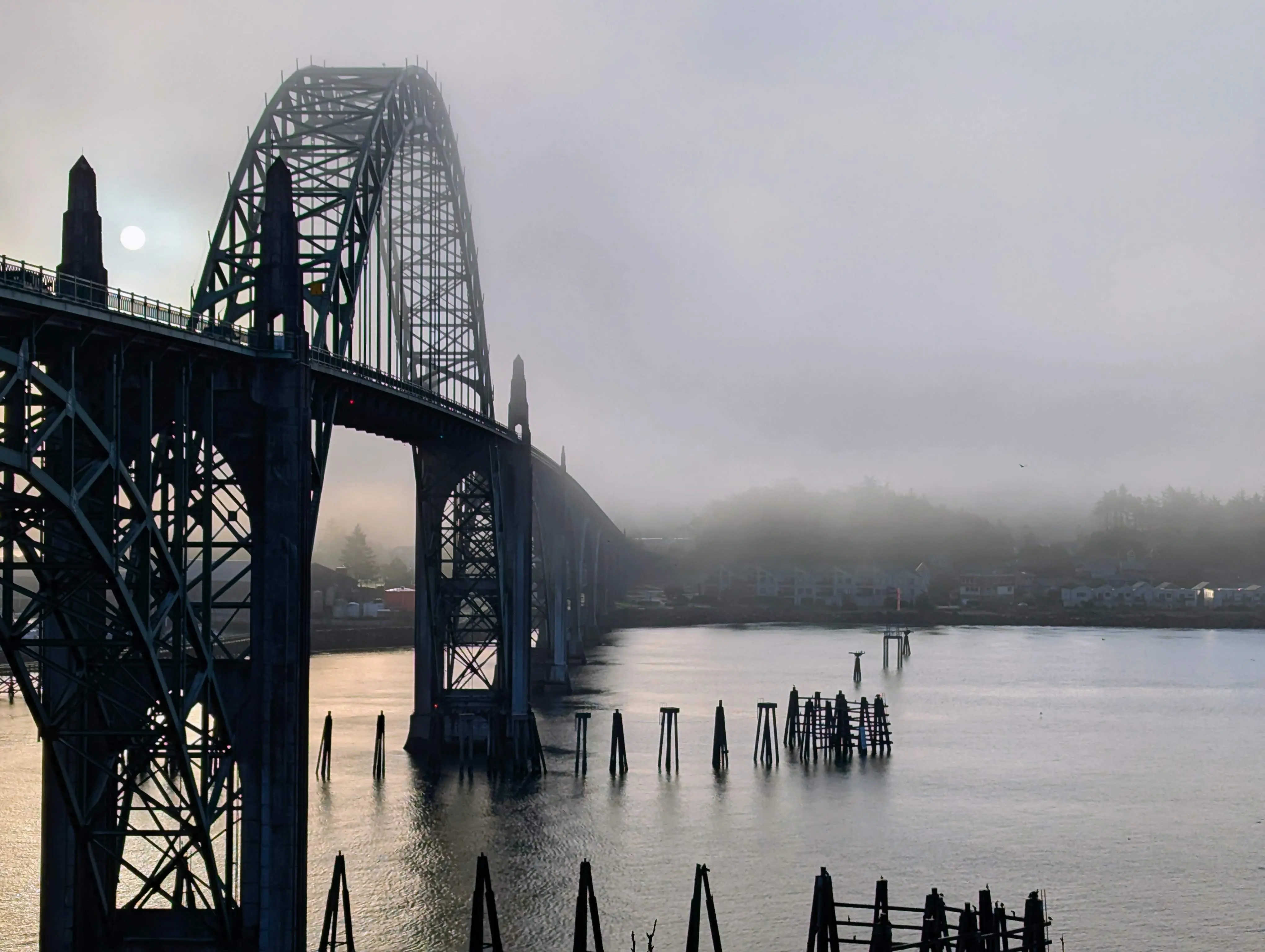 Bridge over bay with fog and sun