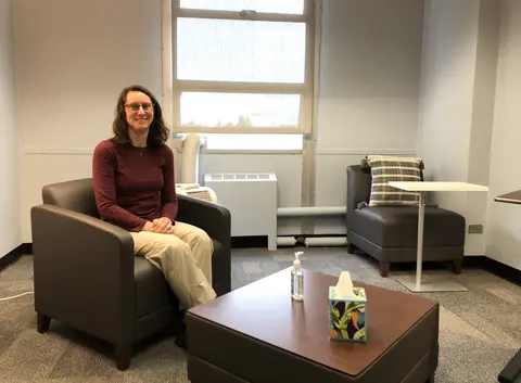 Clinic director Bridget Klest sitting in an armchair in front of a window.