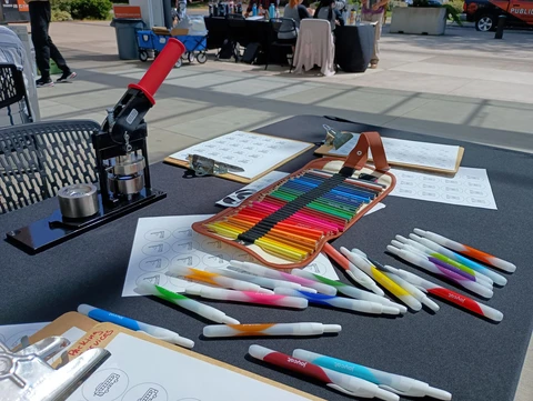 A colorful array of markers and pencils are spread across a table for kids to use.