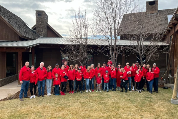 A large group of people all wearing red shirts stand for a photo.