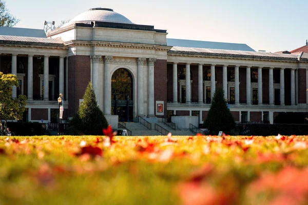 The Memorial Union with autumn leaves on the grass in front.