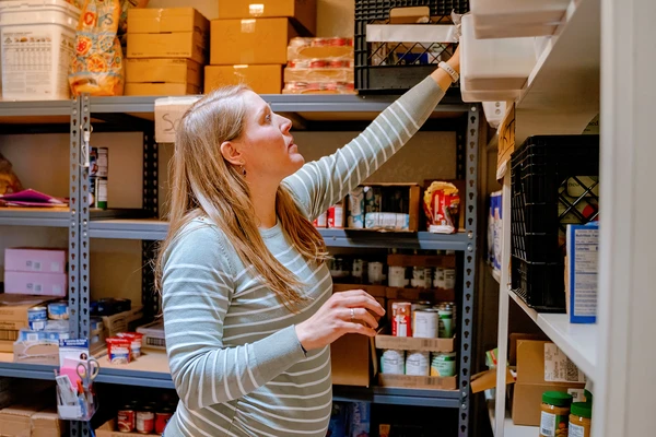 Public health doctoral student Maddie Bean stocks shelves in a food pantry.