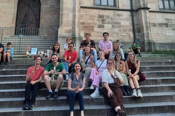Group of Oregon students sitting on the steps of a building in Germany.