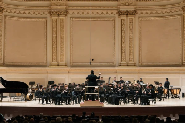 Olin Hannum conducts a large orchestra onstage at Carnegie Hall