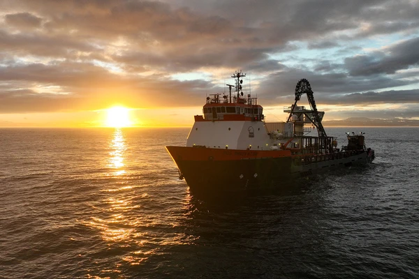 The cable-laying ship, HOS Innovator, at sea at sunset. Photo: Dan Hellin.