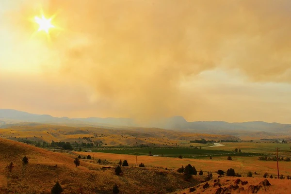 Smoky clouds fill the sky over dry landscape.