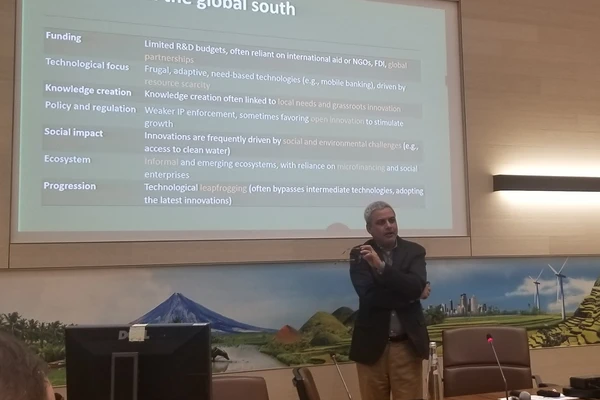 Professor Rajat Panwar lecturing in front of a projector screen on "Innovation in the global south."