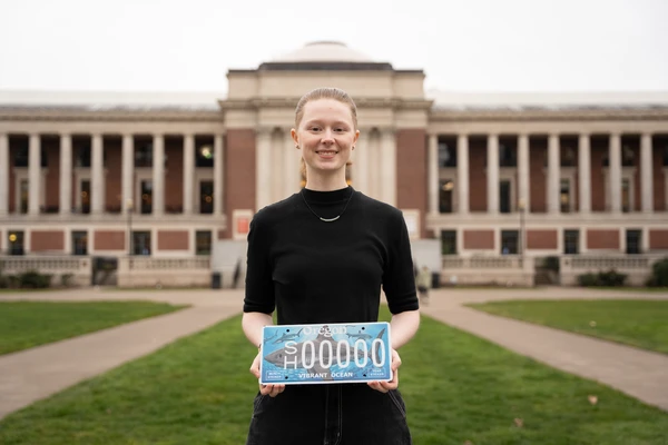 Artist holding license plate