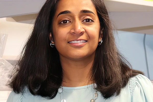 Headshot of Nadia Singh wearing a light sea-green top and necklace. 