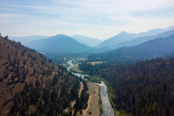 Aerial view of the Klamath River winding between forested mountains.