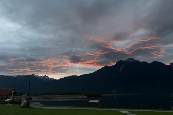 Dark silhouetted mountains in Patagonia against a dramatic cloudy sky.