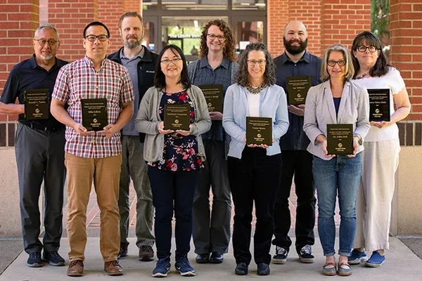 Group of awardees pose with their plaques. 