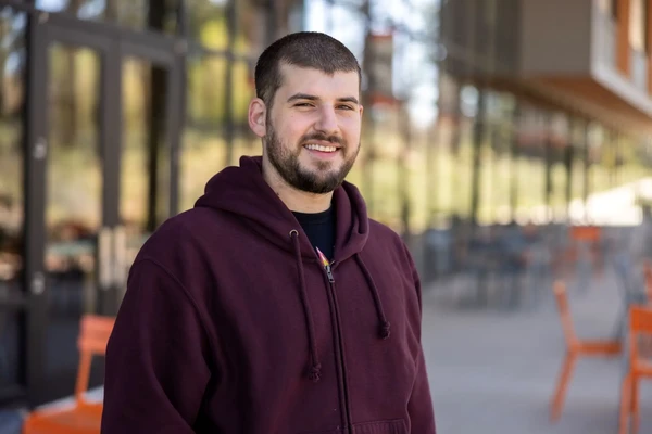 Steven Sheehy, bearded dark-haired man in a maroon hoodie. 