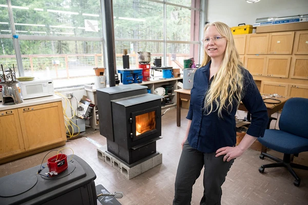 Researcher next to wood stove