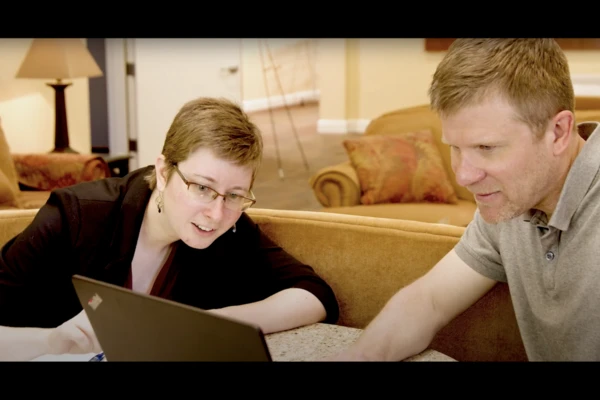 Instructional designer Meghan Naxer works on a laptop with professor Todd Montgomery.