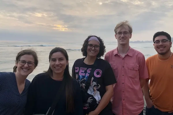 Kelsey Emard, Lorena Cardenas, Kenna Bernardin, Cramer, and Carlos Rodarte pose in front of the ocean in Lima, Peru.