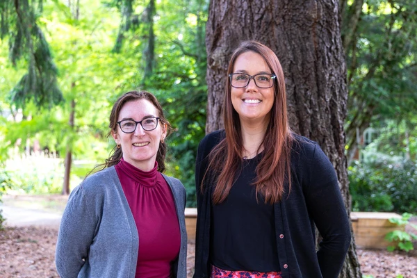 Portrait of two researchers by a tree