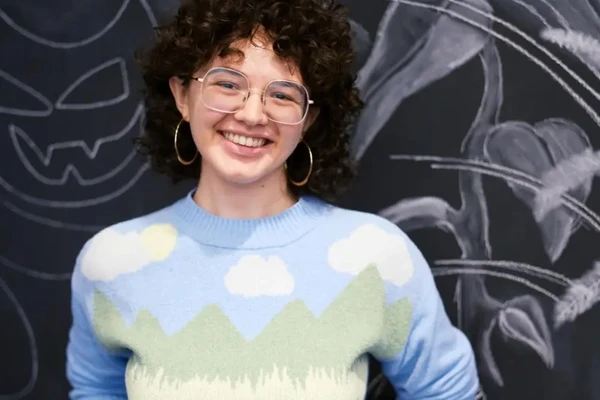 Portrait of artist in front of mural