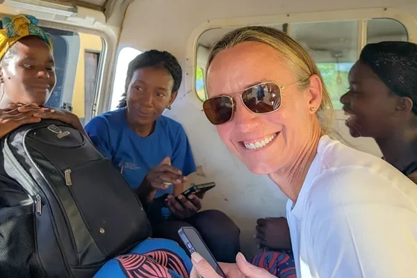 Liz Blanton smiling in a van with three other researchers in Zambia.